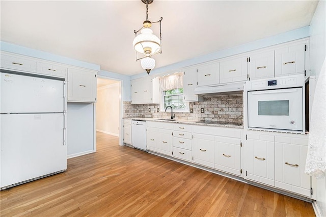 9601 W 97th St, Overland Park, KS 66212 - kitchen with white appliances, under cabinet range hood, a sink, white cabinets, and light wood finished floors