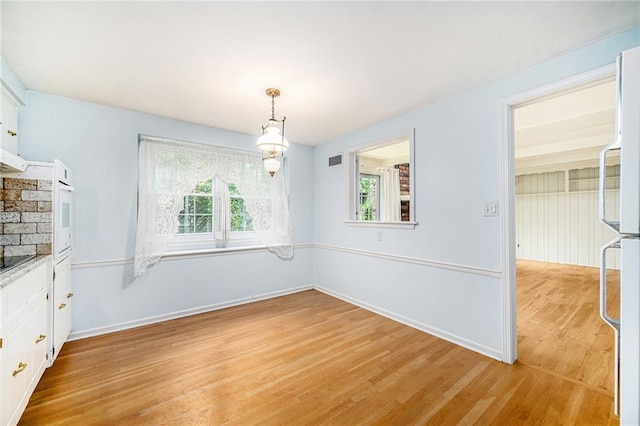 9601 W 97th St, Overland Park, KS 66212 - unfurnished dining area with light wood finished floors and baseboards
