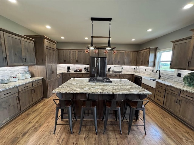 6601 Lakeside Cir, Odessa, MO 64076 - kitchen featuring refrigerator with ice dispenser, tasteful backsplash, a kitchen island, and recessed lighting