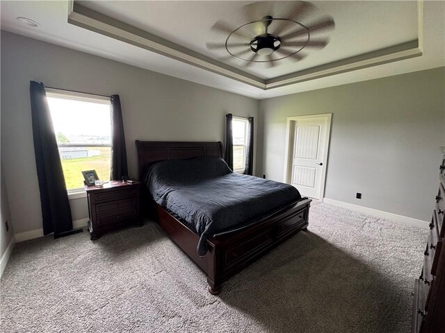 6601 Lakeside Cir, Odessa, MO 64076 - bedroom featuring a tray ceiling, light colored carpet, baseboards, and ceiling fan