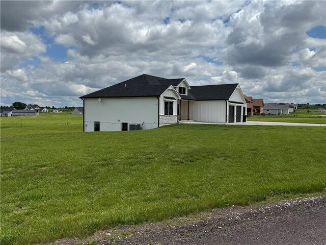 6601 Lakeside Cir, Odessa, MO 64076 - view of side of home featuring driveway, a garage, and a yard