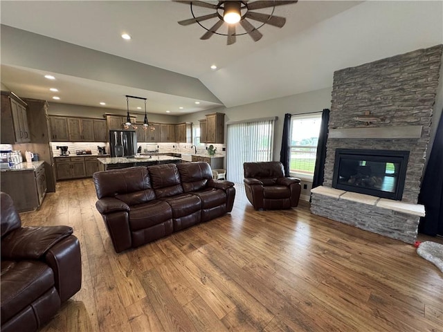 6601 Lakeside Cir, Odessa, MO 64076 - living room with a ceiling fan, wood-type flooring, lofted ceiling, a stone fireplace, and recessed lighting