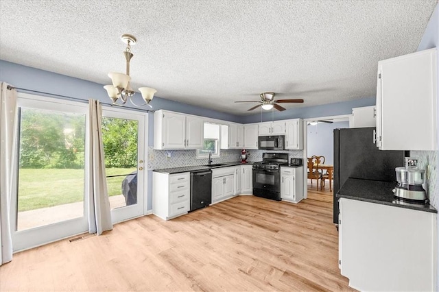 1305 N Hunter Dr, Olathe, KS 66061 - kitchen with black appliances, dark countertops, plenty of natural light, tasteful backsplash, and a textured ceiling