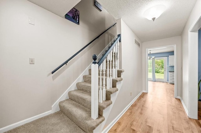 1305 N Hunter Dr, Olathe, KS 66061 - stairway with a textured ceiling and wood finished floors