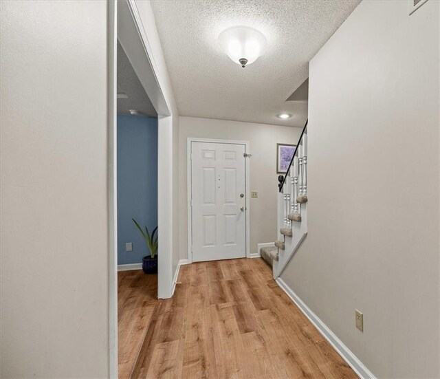 1305 N Hunter Dr, Olathe, KS 66061 - entryway with a textured ceiling, light wood-type flooring, and stairway