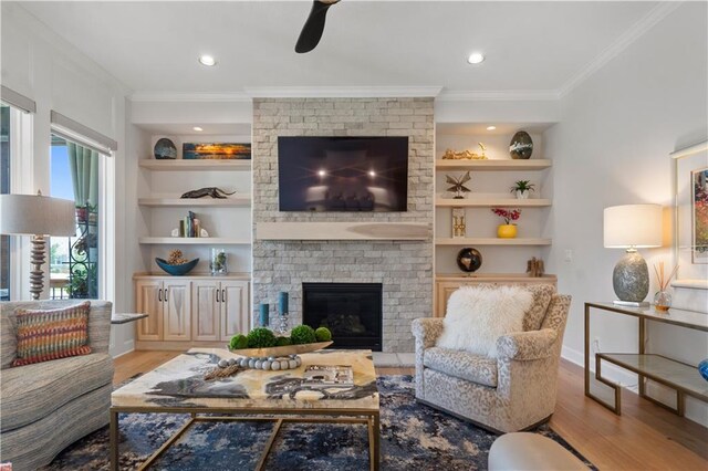 13389 W 147th Ter, Olathe, KS 66062 - living area with wood finished floors, ornamental molding, ceiling fan, a brick fireplace, and built in shelves