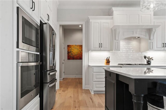 13389 W 147th Ter, Olathe, KS 66062 - kitchen featuring appliances with stainless steel finishes, light countertops, decorative backsplash, white cabinets, and light wood-type flooring
