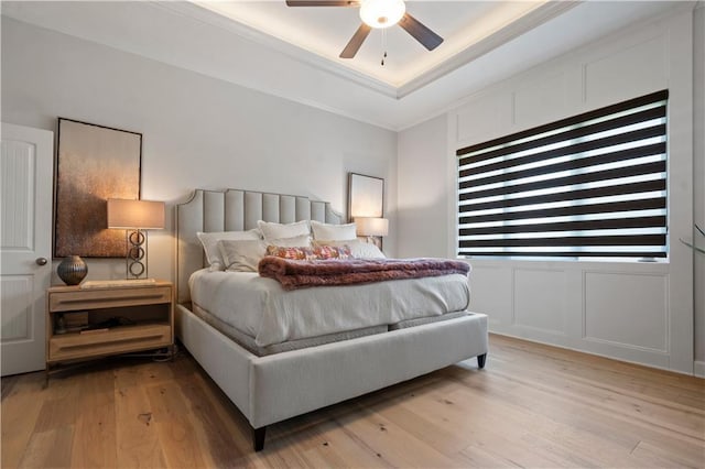 13389 W 147th Ter, Olathe, KS 66062 - bedroom with ornamental molding, light wood-style flooring, a tray ceiling, a decorative wall, and ceiling fan