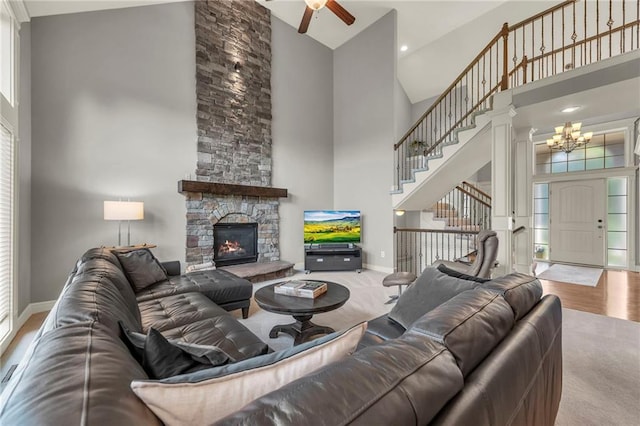 2301 NE 110th St, Kansas City, MO 64155 - living room featuring a towering ceiling, a chandelier, stairway, a ceiling fan, and a fireplace