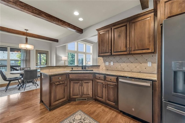 2301 NE 110th St, Kansas City, MO 64155 - kitchen with stainless steel appliances, beamed ceiling, backsplash, light stone counters, and light wood finished floors