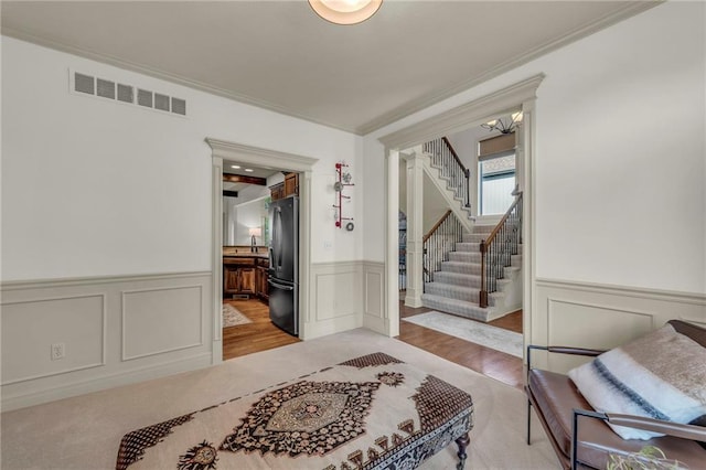 2301 NE 110th St, Kansas City, MO 64155 - entrance foyer with a decorative wall, a wainscoted wall, stairway, ornamental molding, and wood finished floors