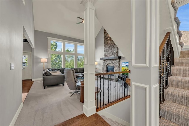 2301 NE 110th St, Kansas City, MO 64155 - interior space featuring a fireplace, wood finished floors, stairs, ceiling fan, and high vaulted ceiling