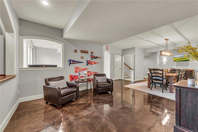 2301 NE 110th St, Kansas City, MO 64155 - living area with finished concrete flooring, stairs, arched walkways, recessed lighting, and a textured ceiling
