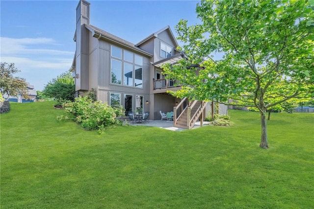 2301 NE 110th St, Kansas City, MO 64155 - rear view of house with a patio area, stairway, a chimney, a deck, and a yard
