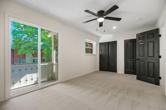 9599 Outlook Dr, Overland Park, KS 66207 - unfurnished bedroom featuring two closets, carpet floors, baseboards, access to outside, and ceiling fan