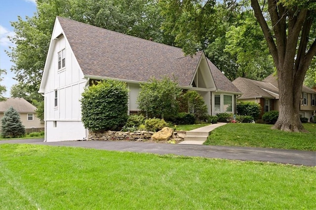 12509 W 100th Ter, Lenexa, KS 66215 - view of front facade featuring a shingled roof, board and batten siding, and a front lawn