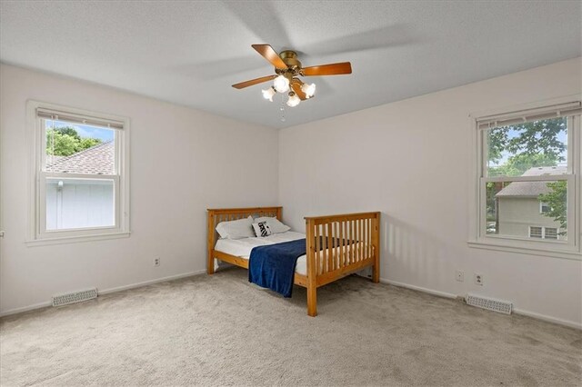 12509 W 100th Ter, Lenexa, KS 66215 - bedroom with multiple windows, carpet flooring, and ceiling fan