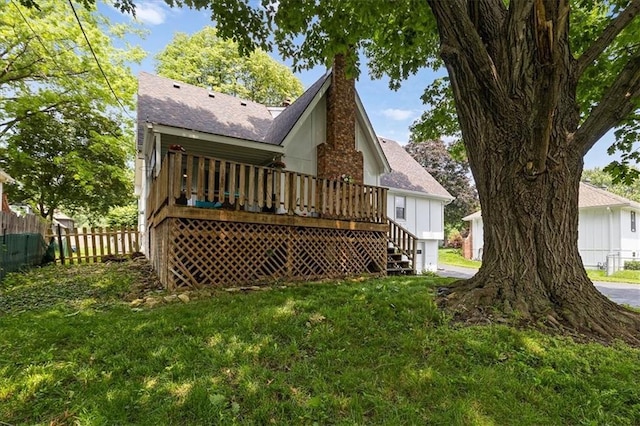 12509 W 100th Ter, Lenexa, KS 66215 - rear view of house featuring a chimney, a wooden deck, and roof with shingles