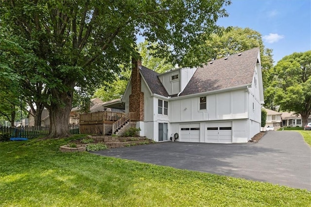 12509 W 100th Ter, Lenexa, KS 66215 - back of property with board and batten siding, driveway, a garage, stairs, and a yard