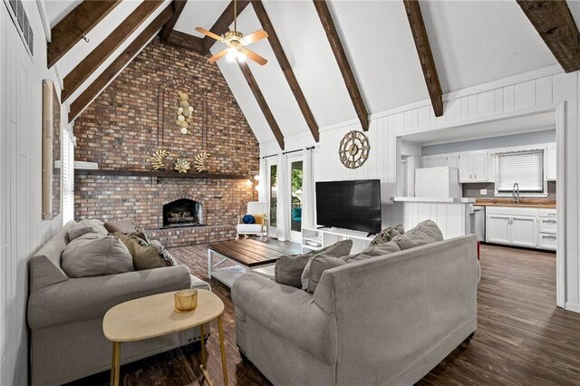 12509 W 100th Ter, Lenexa, KS 66215 - living area featuring a fireplace, ceiling fan, dark wood-type flooring, beamed ceiling, and high vaulted ceiling