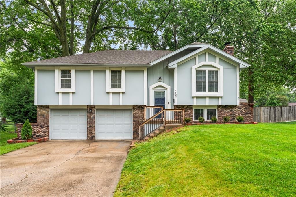 7106 Cody St, Shawnee, KS 66203 - bi-level home featuring brick siding, concrete driveway, a garage, and a chimney