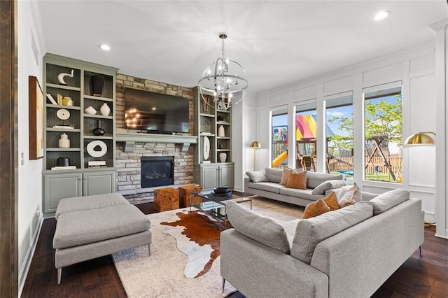 15945 W 165th St, Olathe, KS 66062 - living area with dark wood-style floors, built in features, a stone fireplace, a chandelier, and recessed lighting