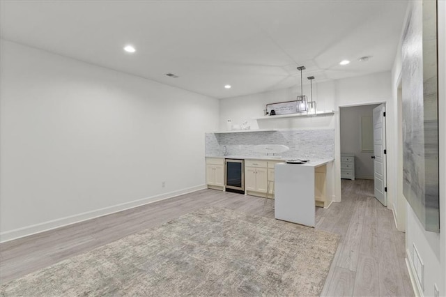 15945 W 165th St, Olathe, KS 66062 - kitchen with light wood-style flooring, beverage cooler, recessed lighting, light countertops, and pendant lighting