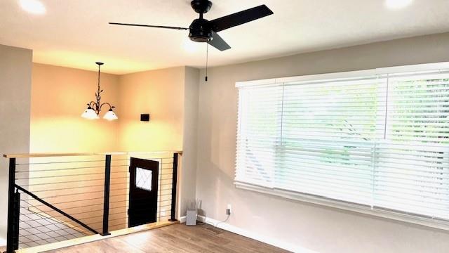 1636 S Poplar St, Ottawa, KS 66067 - entrance foyer with a chandelier, ceiling fan, wood finished floors, baseboards, and healthy amount of natural light