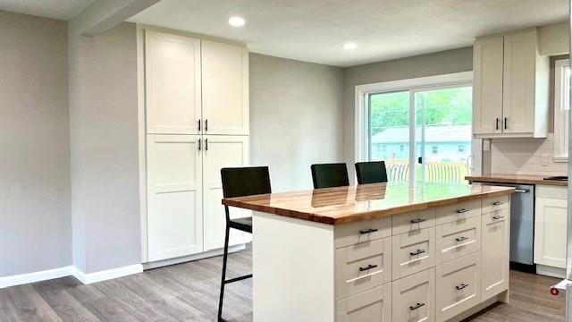 1636 S Poplar St, Ottawa, KS 66067 - kitchen featuring light wood-style floors, recessed lighting, a kitchen breakfast bar, a kitchen island, and tasteful backsplash