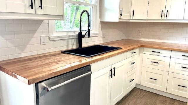 1636 S Poplar St, Ottawa, KS 66067 - kitchen with dishwasher, a sink, butcher block countertops, and decorative backsplash