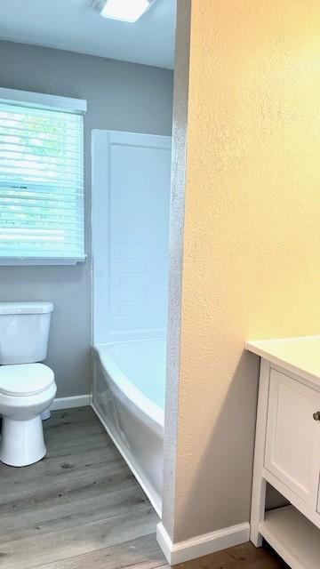 1636 S Poplar St, Ottawa, KS 66067 - bathroom with toilet, wood finished floors, baseboards, vanity, and a textured wall