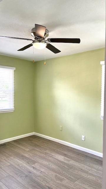 1636 S Poplar St, Ottawa, KS 66067 - unfurnished room with wood finished floors, baseboards, and ceiling fan
