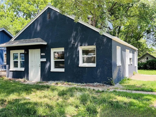 6823 S Benton Ave, Kansas City, MO 64132 - view of front of property with stucco siding and a front lawn