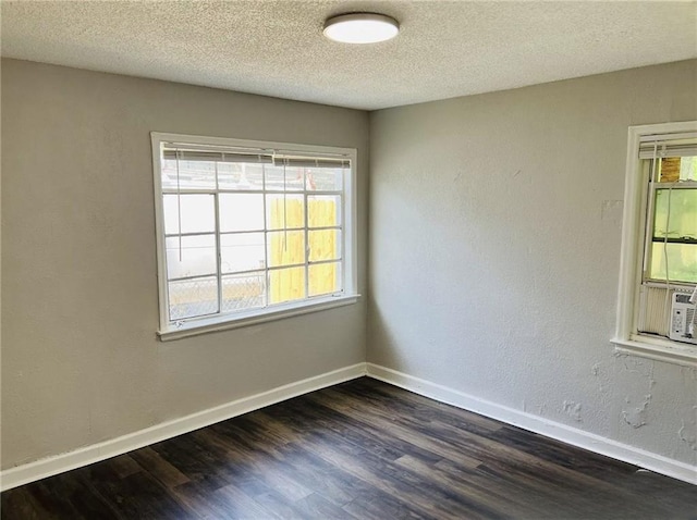 6823 S Benton Ave, Kansas City, MO 64132 - unfurnished room with dark wood finished floors, baseboards, and a textured ceiling