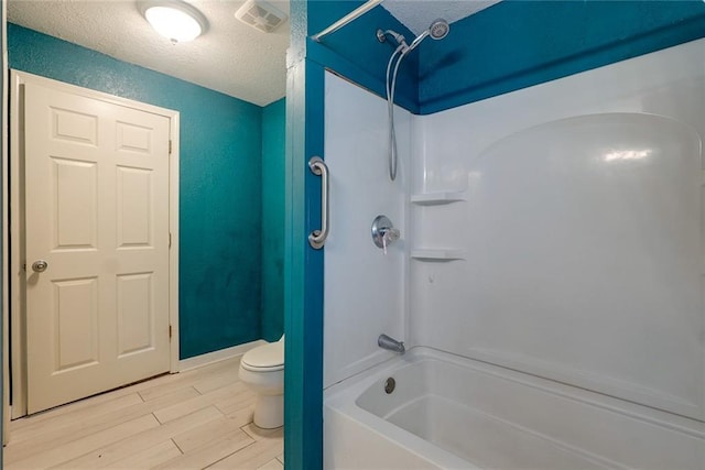 814 E Hayward Ave, Independence, MO 64050 - bathroom featuring toilet, a textured ceiling, wood finished floors, and shower / washtub combination