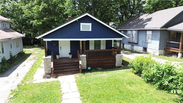 7216 Indiana Ave, Kansas City, MO 64132 - bungalow-style home featuring a porch, a front lawn, and driveway