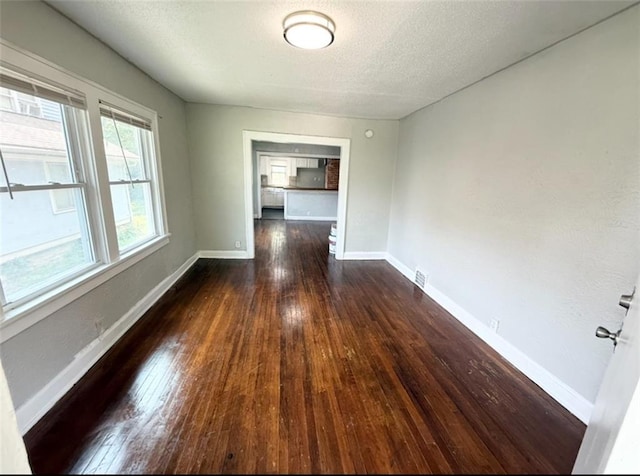 7216 Indiana Ave, Kansas City, MO 64132 - unfurnished room with hardwood / wood-style floors, baseboards, and a textured ceiling