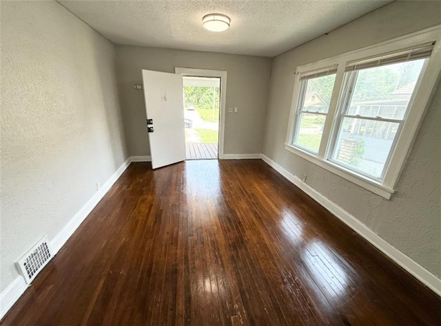 7216 Indiana Ave, Kansas City, MO 64132 - empty room with a textured wall, plenty of natural light, hardwood / wood-style flooring, a textured ceiling, and baseboards