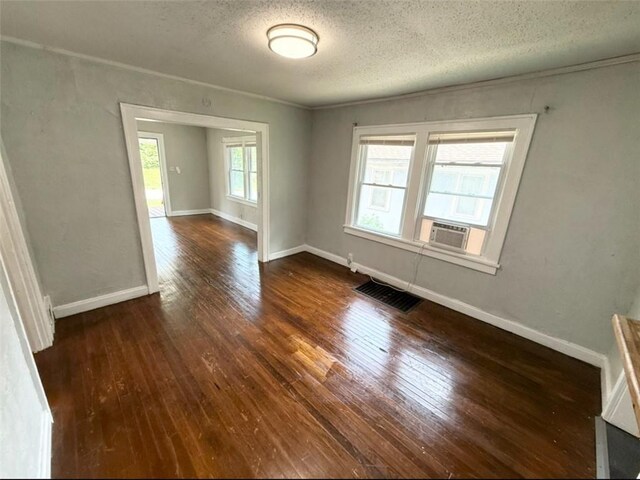 7216 Indiana Ave, Kansas City, MO 64132 - empty room featuring dark wood-type flooring, a textured ceiling, cooling unit, and baseboards