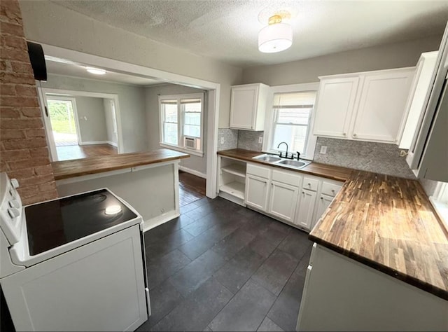 7216 Indiana Ave, Kansas City, MO 64132 - kitchen featuring wood counters, white range with electric stovetop, a sink, plenty of natural light, and a textured ceiling