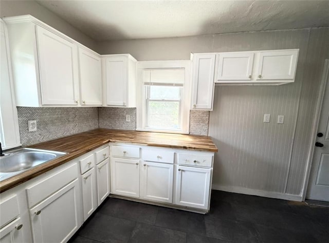 7216 Indiana Ave, Kansas City, MO 64132 - kitchen featuring wooden counters, decorative backsplash, white cabinetry, and a sink