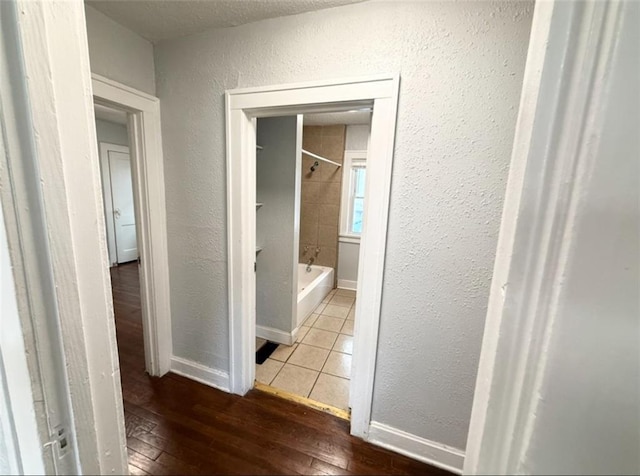 7216 Indiana Ave, Kansas City, MO 64132 - corridor featuring a textured wall, hardwood / wood-style floors, and baseboards