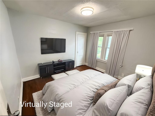 7216 Indiana Ave, Kansas City, MO 64132 - bedroom with baseboards, dark wood-style flooring, and a textured ceiling