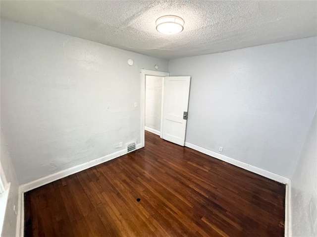 7216 Indiana Ave, Kansas City, MO 64132 - spare room with dark wood finished floors, baseboards, and a textured ceiling