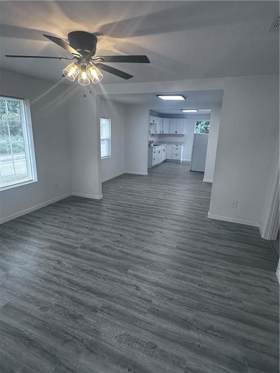 6230 Sherman St, Saint Joseph, MO 64504 - unfurnished living room featuring baseboards, dark wood-style flooring, and plenty of natural light