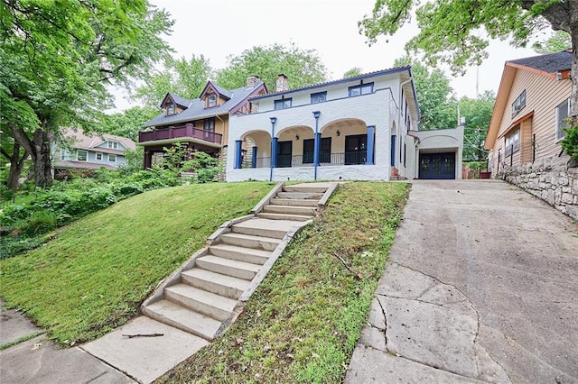 918 W 32nd Ter, Kansas City, MO 64111 - view of front of property featuring concrete driveway, a front lawn, a garage, stairway, and a chimney