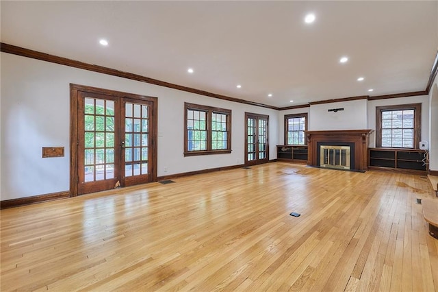 918 W 32nd Ter, Kansas City, MO 64111 - unfurnished living room with crown molding, french doors, light wood-style flooring, baseboards, and a fireplace with flush hearth