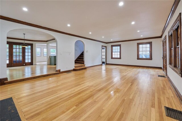 918 W 32nd Ter, Kansas City, MO 64111 - unfurnished living room with light wood-style flooring, arched walkways, ornamental molding, recessed lighting, and baseboards