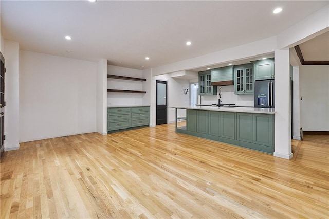 918 W 32nd Ter, Kansas City, MO 64111 - kitchen with open shelves, stainless steel fridge, green cabinets, light wood finished floors, and recessed lighting