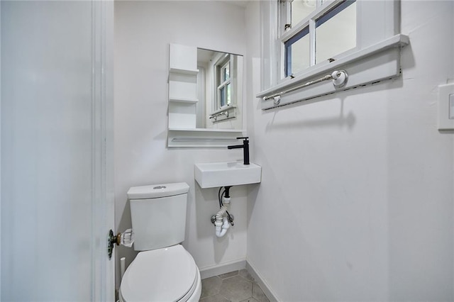 918 W 32nd Ter, Kansas City, MO 64111 - half bath with toilet, baseboards, a sink, and tile patterned flooring